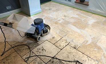 Image of scrubbing a travertine floor by Fabritec Tile Cleaning